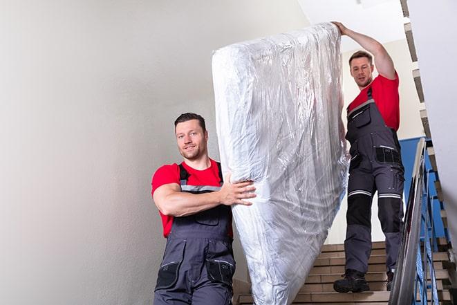 team of workers lifting a box spring out of a house in Julian, CA